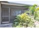 A covered front porch featuring tile floors and lush tropical landscaping around the entrance at 3140 Jackson Dr, Holiday, FL 34691