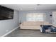 Bright living room featuring a comfortable sofa, large window, and sleek flooring at 3140 Jackson Dr, Holiday, FL 34691