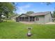 Lush backyard featuring a screened-in porch with a tranquil setting at 35046 Smoketree Ln, Dade City, FL 33523