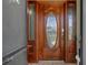 Elegant wood front door featuring glass panels and decorative hardware provides a welcoming entrance at 35046 Smoketree Ln, Dade City, FL 33523