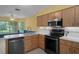 Charming kitchen featuring stainless steel appliances, wood cabinetry, and bright countertops at 35046 Smoketree Ln, Dade City, FL 33523
