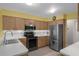 Well-lit kitchen featuring stainless steel appliances, oak cabinets, and tile flooring at 35046 Smoketree Ln, Dade City, FL 33523
