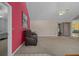 Spacious living room with carpet, a ceiling fan, a sliding glass door, and a red accent wall at 35046 Smoketree Ln, Dade City, FL 33523