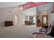 Open-concept living room with carpet, high ceilings, a dining area, and front door at 35046 Smoketree Ln, Dade City, FL 33523