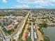 An aerial view showcasing the property's convenient location near a lake, road, and businesses at 3832 Sailmaker Ln # 3832, Holiday, FL 34691
