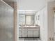 Bathroom featuring double sinks, vanity with granite countertops, and tiled shower at 3832 Sailmaker Ln # 3832, Holiday, FL 34691
