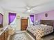 Comfortable bedroom featuring a ceiling fan, closet, wood furnishings and purple drapes at 3832 Sailmaker Ln # 3832, Holiday, FL 34691