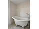 Bathroom with a clawfoot tub, neutral tile, and vintage-style plumbing fixtures at 4048 Bluefish Dr, Hernando Beach, FL 34607