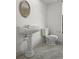 Bathroom featuring a pedestal sink, a toilet, wainscoting, and decorative mirror at 4048 Bluefish Dr, Hernando Beach, FL 34607
