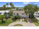 Attractive two-story home surrounded by lush landscaping and mature palm trees at 4048 Bluefish Dr, Hernando Beach, FL 34607