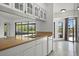 Bright kitchen featuring white cabinets, countertops, a breakfast bar, and access to the lanai at 4048 Bluefish Dr, Hernando Beach, FL 34607