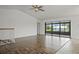 Open-concept living room with wood floors, bright natural light and sliding glass doors to a screened-in porch at 4048 Bluefish Dr, Hernando Beach, FL 34607