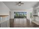 Spacious living room with wood floors, ceiling fan, and sliding glass doors leading to a screened-in patio at 4048 Bluefish Dr, Hernando Beach, FL 34607