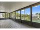 Screened porch with wood floor offering waterfront views of the surrounding nature at 4048 Bluefish Dr, Hernando Beach, FL 34607