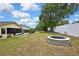 Spacious backyard featuring a stone fire pit, lush landscaping, and a white privacy fence at 4072 Everett Ave, Spring Hill, FL 34609