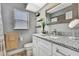 Bathroom featuring a granite countertop, chrome fixtures, and decorative shelves for extra storage at 4072 Everett Ave, Spring Hill, FL 34609