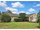 Wide view of a charming single-story home featuring a well-manicured lawn, lush landscaping, and a side entry garage at 4072 Everett Ave, Spring Hill, FL 34609