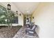 Inviting front porch with two wicker chairs, lantern style lighting, and brick flooring at 4072 Everett Ave, Spring Hill, FL 34609