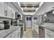 Open kitchen features stainless steel appliances, white cabinets, granite countertops, and wood beams at 4072 Everett Ave, Spring Hill, FL 34609