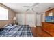 A view of the bedroom with hardwood floors, ceiling fan, and closet doors at 4350 Sawgrass Blvd, New Port Richey, FL 34653