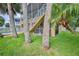 Backyard and lawn featuring the stilt construction of the home, as well as mature palm trees and tropical landscaping at 4460 Flounder Dr, Hernando Beach, FL 34607
