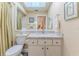 Bright bathroom features a skylight, a white vanity with a marble countertop, and framed art on the wall at 4460 Flounder Dr, Hernando Beach, FL 34607