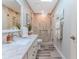 Well-lit bathroom featuring marble countertops, wood-look tile, and a tiled walk-in shower at 4460 Flounder Dr, Hernando Beach, FL 34607