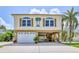 Charming two-story coastal home with a garage, carport, and palm tree accents at 4460 Flounder Dr, Hernando Beach, FL 34607