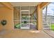 A ground-level, screened lanai with tile flooring and a door to the backyard and stairs leading to an upper floor at 4460 Flounder Dr, Hernando Beach, FL 34607