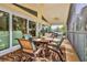 Comfortable dining set with a leafy rug decorates a screened patio overlooking the waterfront at 4460 Flounder Dr, Hernando Beach, FL 34607