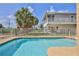 Sparkling pool view highlighting the backyard's fenced perimeter and the home's elevated screened lanai at 4460 Flounder Dr, Hernando Beach, FL 34607