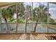 The view of the water from the tiled, screened-in patio is framed by tall palm trees at 4460 Flounder Dr, Hernando Beach, FL 34607