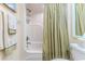 Bright bathroom features a white shower with a tan-striped shower curtain and decorative towels at 4460 Flounder Dr, Hernando Beach, FL 34607