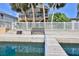 Waterfront view of the property featuring a dock, bench, and fenced backyard, perfect for outdoor relaxation by the water at 4460 Flounder Dr, Hernando Beach, FL 34607
