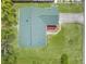 Aerial view showcases a home with a green roof, well-maintained yard, and driveway, emphasizing its curb appeal and setting at 5035 Harbinger Rd, Spring Hill, FL 34608