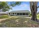 Lush backyard with mature trees, green grass, and a screen patio for outdoor enjoyment at 5035 Harbinger Rd, Spring Hill, FL 34608