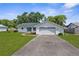 Well-manicured front yard and long driveway to attached two-car garage highlight this home's curb appeal at 5035 Harbinger Rd, Spring Hill, FL 34608