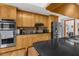 Well-equipped kitchen with stainless steel appliances, black countertops, and built-in microwave and oven at 5035 Harbinger Rd, Spring Hill, FL 34608
