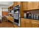 Bright kitchen features natural wood cabinetry, stainless steel oven and microwave, and black countertop space at 5035 Harbinger Rd, Spring Hill, FL 34608