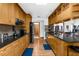 Spacious kitchen featuring modern appliances, black countertops, and natural wood cabinets at 5035 Harbinger Rd, Spring Hill, FL 34608