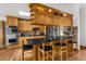 Open kitchen features a black countertop island with seating, natural wood cabinets, and stainless steel appliances at 5035 Harbinger Rd, Spring Hill, FL 34608