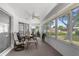 Light-filled sunroom with many windows, ceiling fan, and access to backyard at 5035 Harbinger Rd, Spring Hill, FL 34608