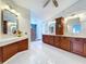 Bathroom featuring double vanities, marble countertops, and a walk-in shower at 5249 Wellfield Rd, New Port Richey, FL 34655