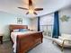 Comfortable bedroom showcasing a wood frame bed, chair, ceiling fan and a bright window at 5249 Wellfield Rd, New Port Richey, FL 34655