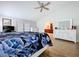 Bright bedroom featuring white furniture, a view into the bathroom, and wood-look tile flooring at 5249 Wellfield Rd, New Port Richey, FL 34655