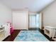 Cozy bedroom featuring wood floors, a blue rug, white wicker furniture and access to other areas of the home at 5249 Wellfield Rd, New Port Richey, FL 34655