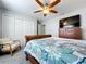 Bedroom with a sleigh bed, wooden dresser with a TV, ceiling fan and a white upholstered chair at 5249 Wellfield Rd, New Port Richey, FL 34655