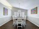 Formal dining area showcases shuttered windows, chandelier, wainscoting, and rich hardwood flooring at 5249 Wellfield Rd, New Port Richey, FL 34655