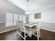 Bright dining room featuring a classic chandelier, shuttered windows, and comfortable seating at 5249 Wellfield Rd, New Port Richey, FL 34655