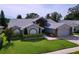 Well-maintained home with mature landscaping, arched windows, and a brick-accented two-car garage at 5249 Wellfield Rd, New Port Richey, FL 34655